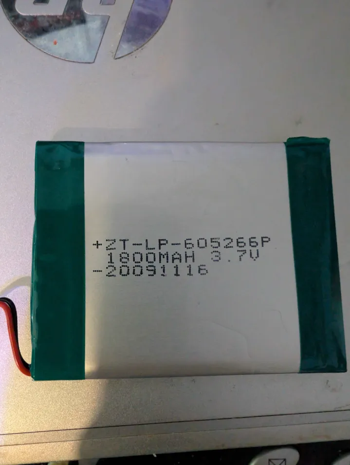 Photo of the battery in question.  The same thing is printed on both sides, with the only difference being the polarity.  What's written on it is:

+ZT-LP-605266P
 1600MAH 3.7V
-20091116
