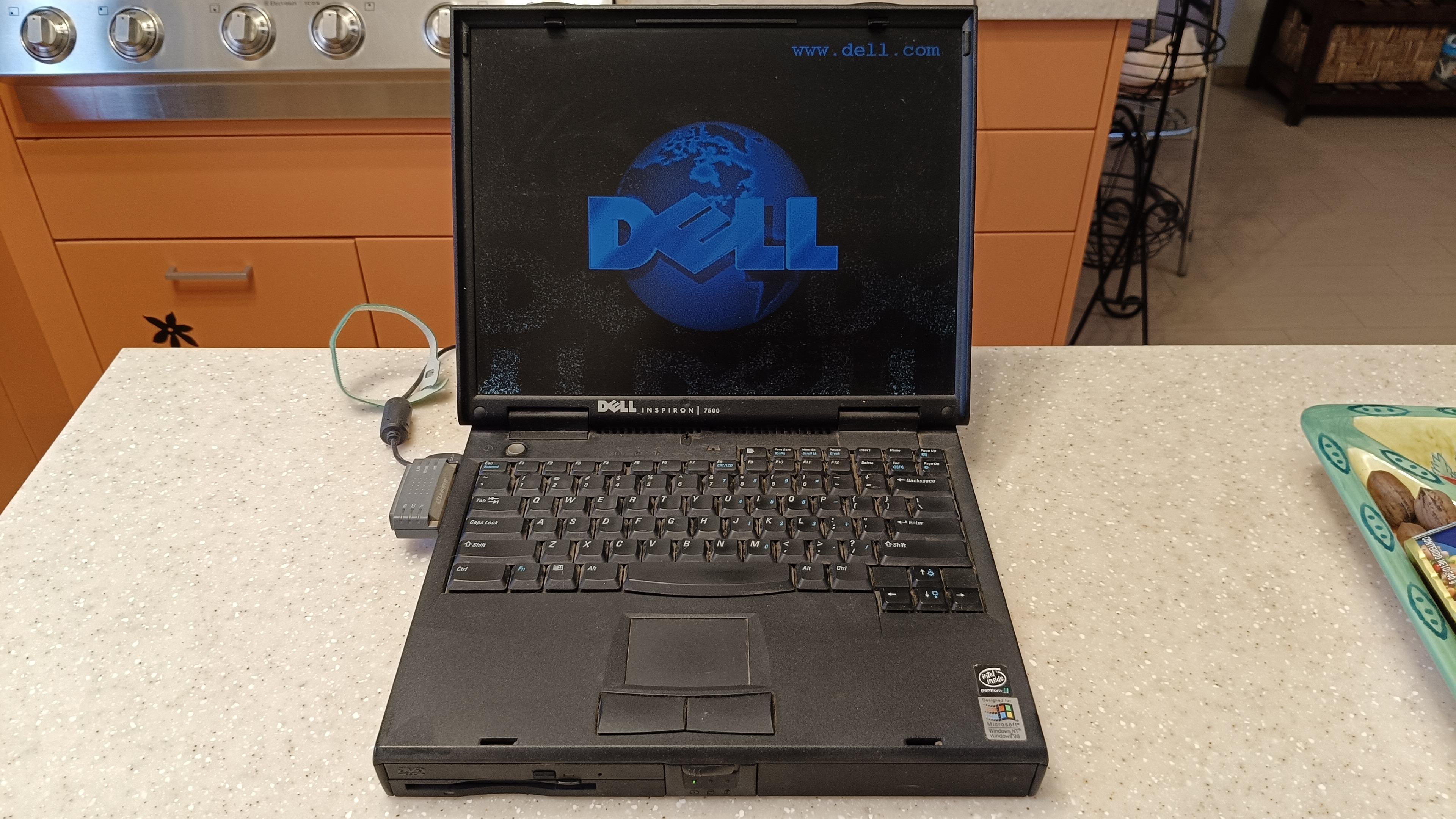 Old Dell laptop on kitchen counter booting up. Laptop is black and chunky.

Screen is open and computer is booting into dell logo